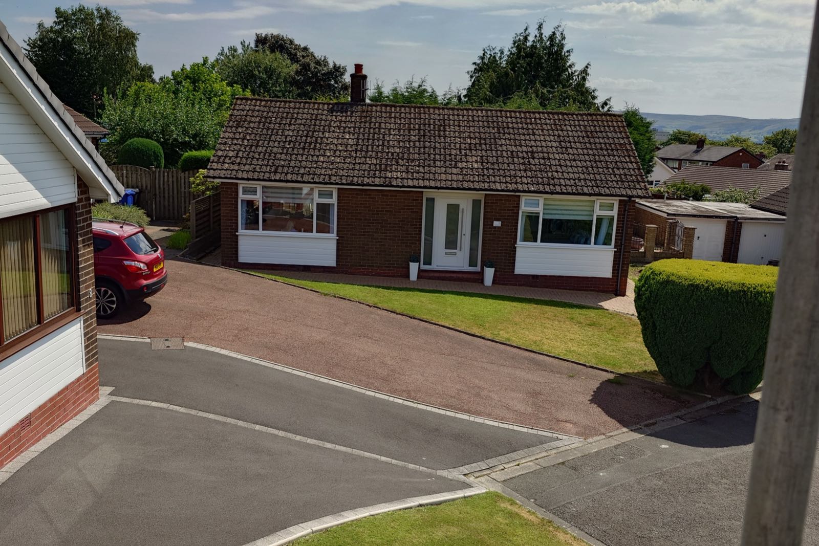 A bungalow with its roof finished, seen from the roof opposite